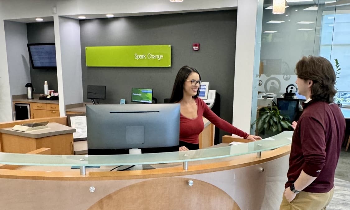 An Innovations FCU team member assisting a member at the check-in desk.